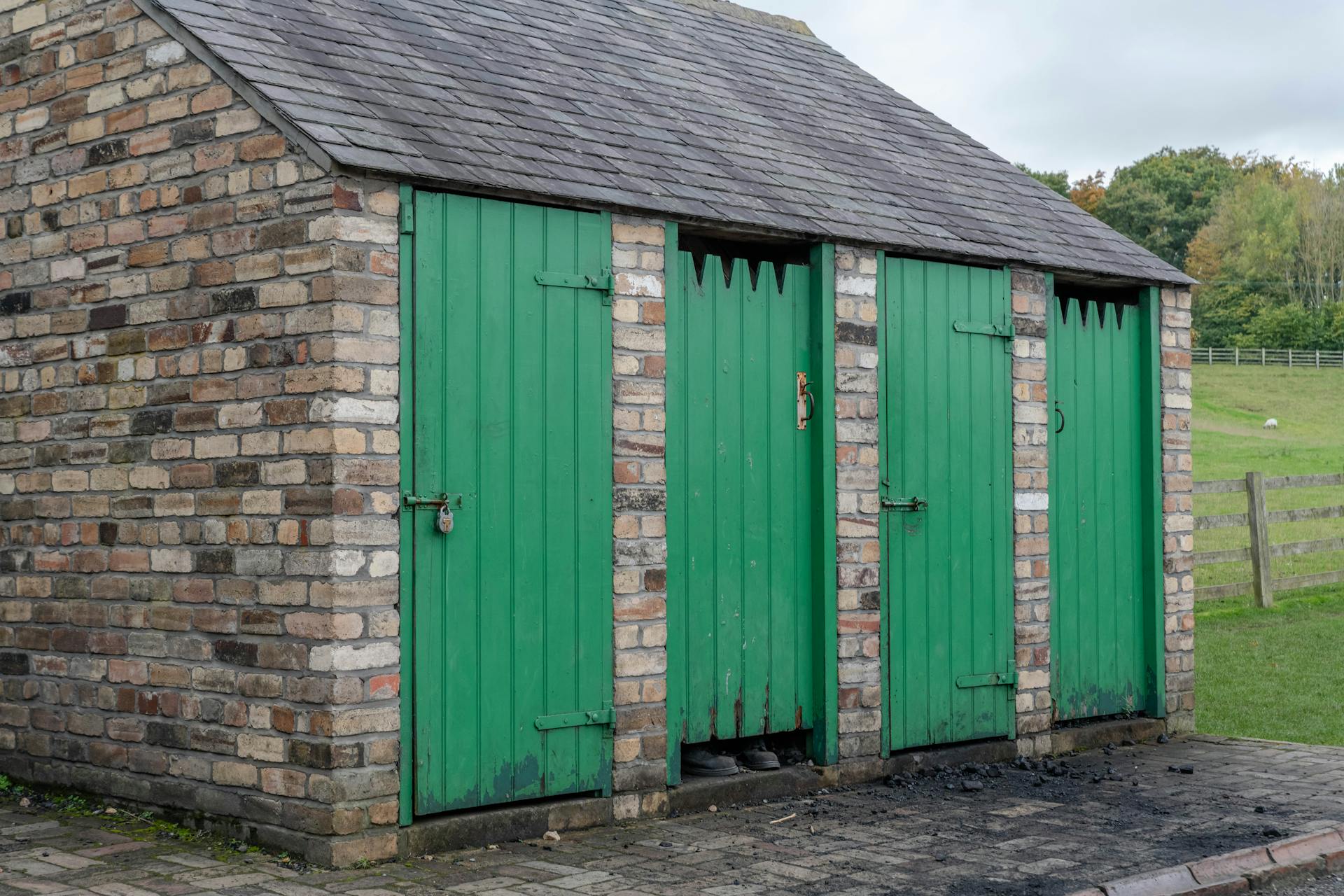 Stone Wall Shed with Green Door on a Farm