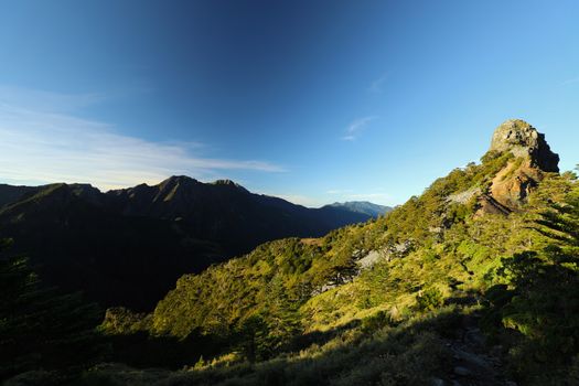 Breathtaking view of a mountainous landscape with clear blue sky and lush green terrain.