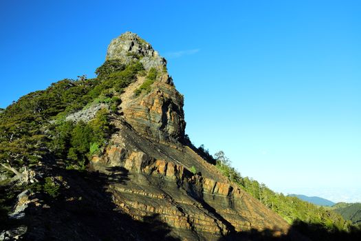 Stunning view of a rocky mountain peak against a clear blue sky, perfect for nature enthusiasts.