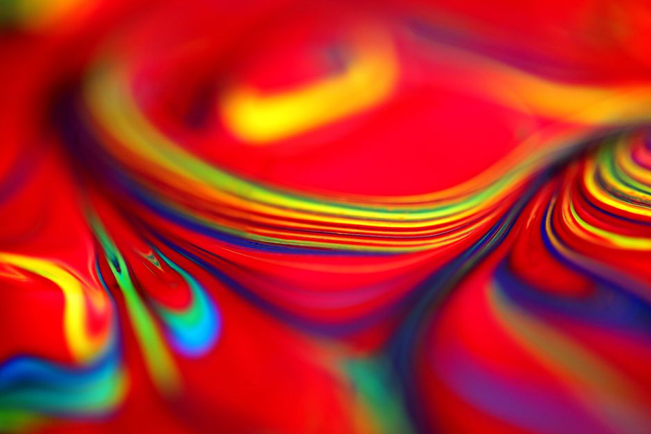 Close-up of vibrant swirls in red and rainbow colors, creating an abstract pattern.