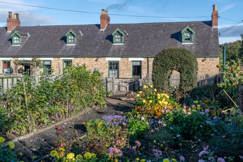 Free Quaint cottage in Beamish, England, surrounded by a vibrant flower garden. Stock Photo