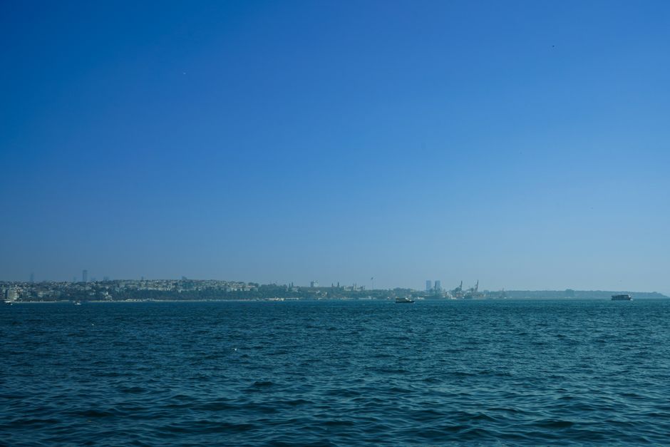 A scenic view of Istanbul's skyline across the Bosphorus Strait under a clear blue sky.
