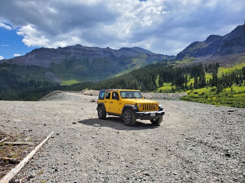View of a Yellow Jeep Wrangles Parked in Mountains 