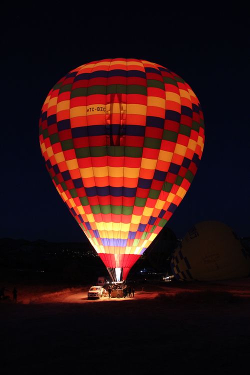 Free Vibrant hot air balloon glowing at night in Cappadocia, Turkey, under a starry sky. Stock Photo