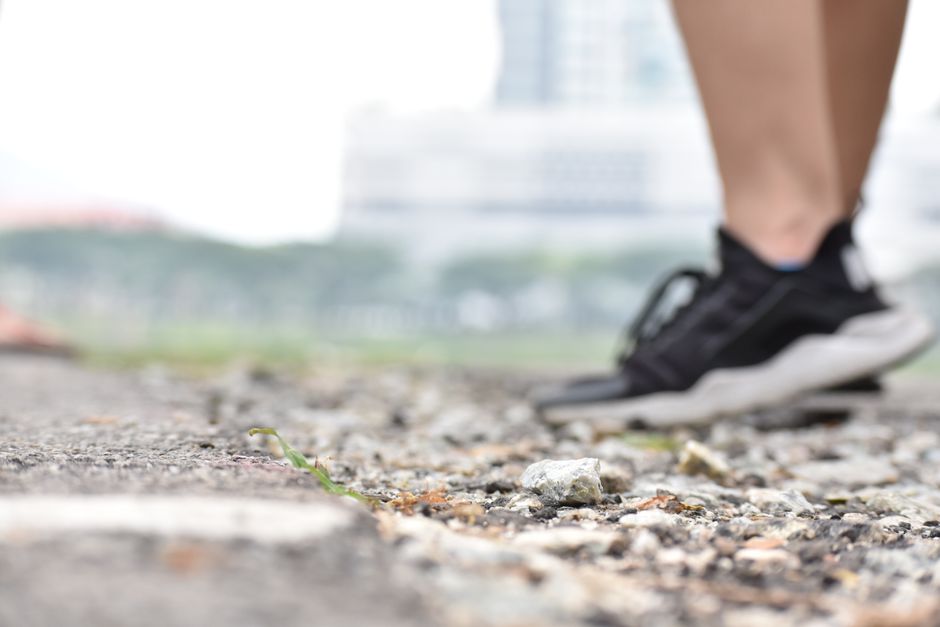Blurred sneakers on rocky ground, exploring nature outdoors.