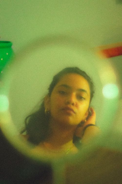 Free Captivating portrait of a woman reflected in a mirror with a vintage aesthetic. Stock Photo