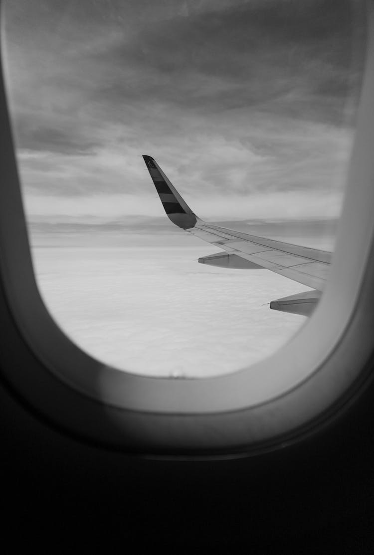 Grayscale Photo Of An Airplane Flying On Mid Air