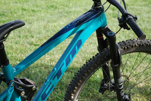 Detailed close-up of a blue mountain bike parked on green grass.