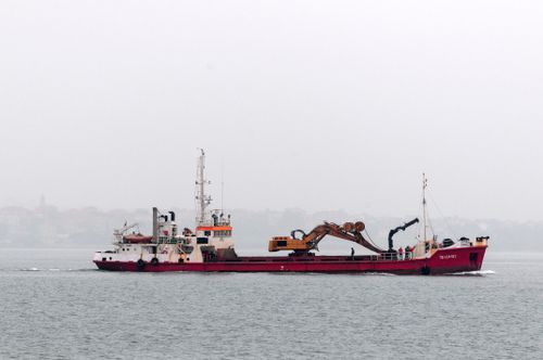 Free A TSHD vessel with crane sails through misty waters near Santander, Spain. Stock Photo