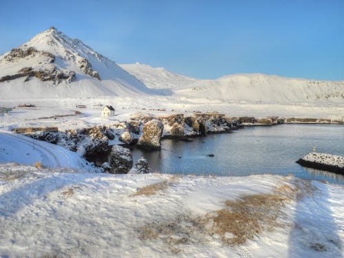 White Snow Covered Mountain Near Body of Water