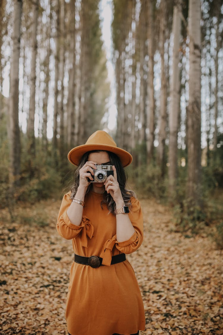 Woman Taking Photograph In Autumn 