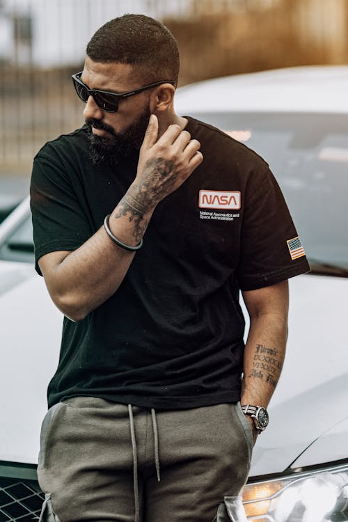 Man in Black shirt Leaning on a Car Hood