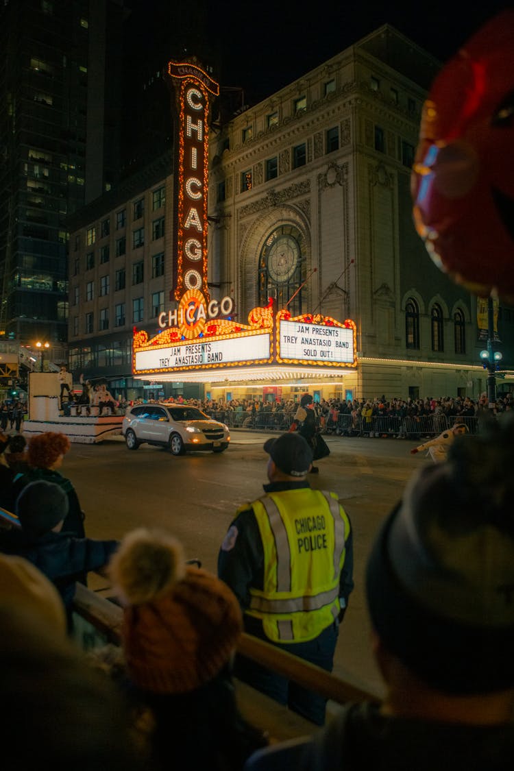 A Crowd Celebrating A Parade In Front Of The Chicago Theatre