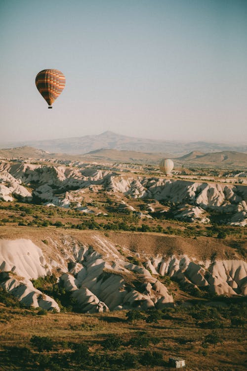 A Hot Air Balloon Floating Above Hills