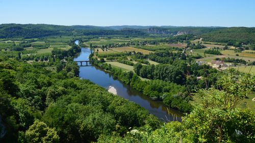 Free Aerial view of a peaceful river flowing through a lush green valley, perfect for summer travel inspiration. Stock Photo