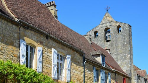 Free Old stone village with belfry and shutters in France under a clear blue sky. Stock Photo