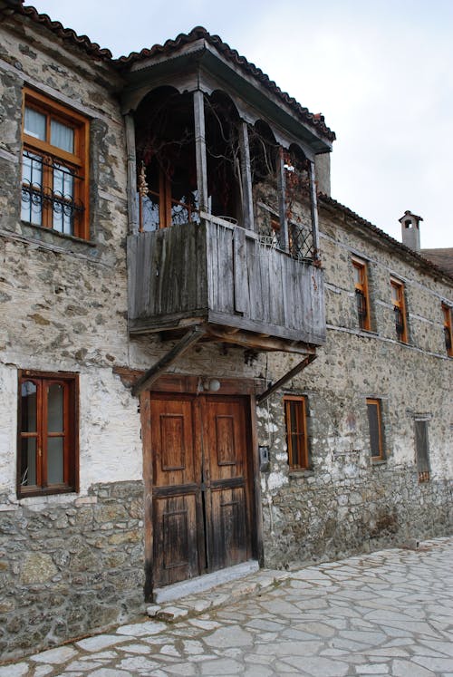 Facade of an Abandoned, Stone House with a Wooden Balcony 