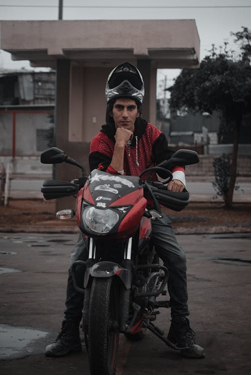 Man in Black and Red Hoodie Jacket Riding on Black Motorcycle
