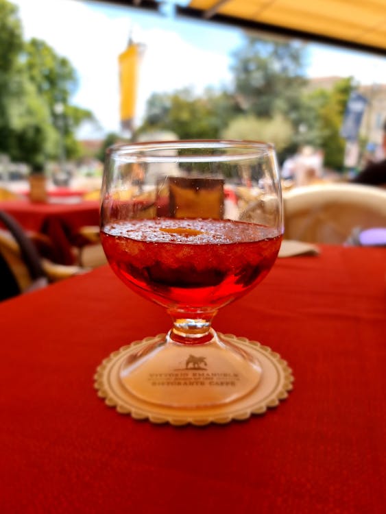 Close-Up Shot of a Glass of Red Wine on Red Textile