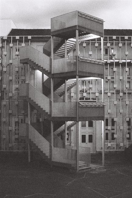 A striking black and white image of a metal staircase against a modern building in Braga, Portugal.