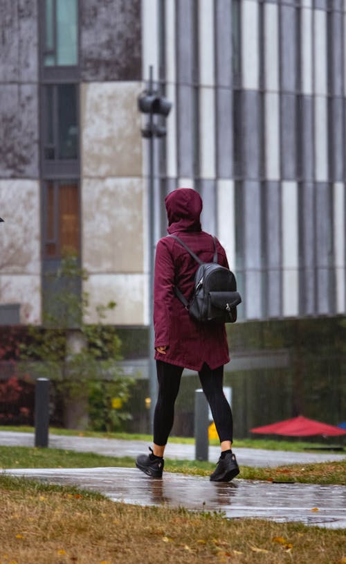 A Person in Red Jacket Walking on the Street