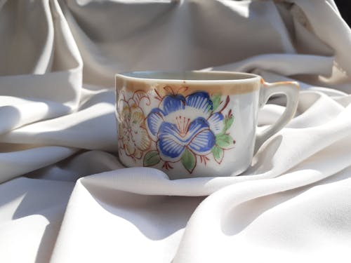 Floral Porcelain Cup on White Textile