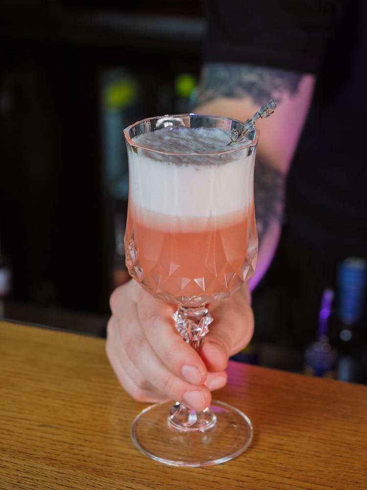 Person Hand With Cocktail At Bar Counter