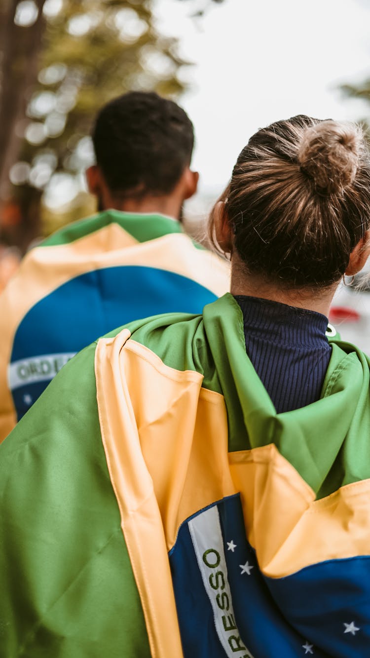 People Walking With Flags On Backs