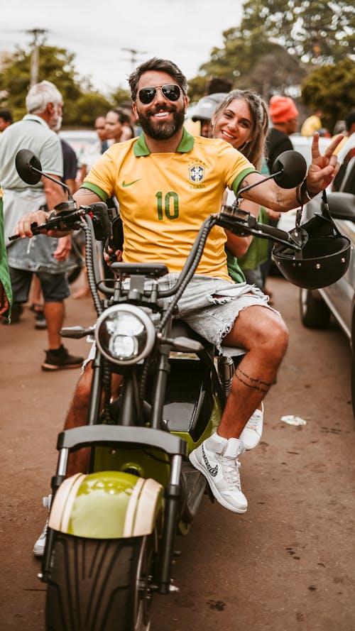 Man in Yellow Polo Shirt Sitting on Black Motorcycle