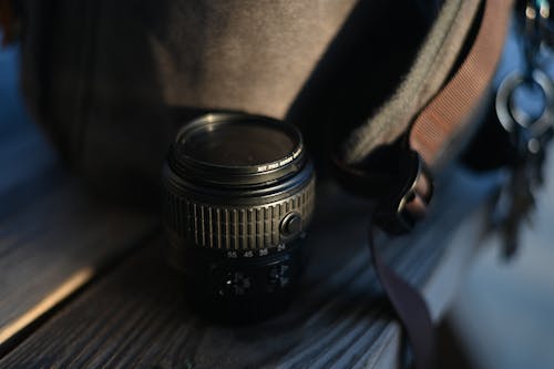 Close-Up Shot of a Camera Lens on Wooden Surface