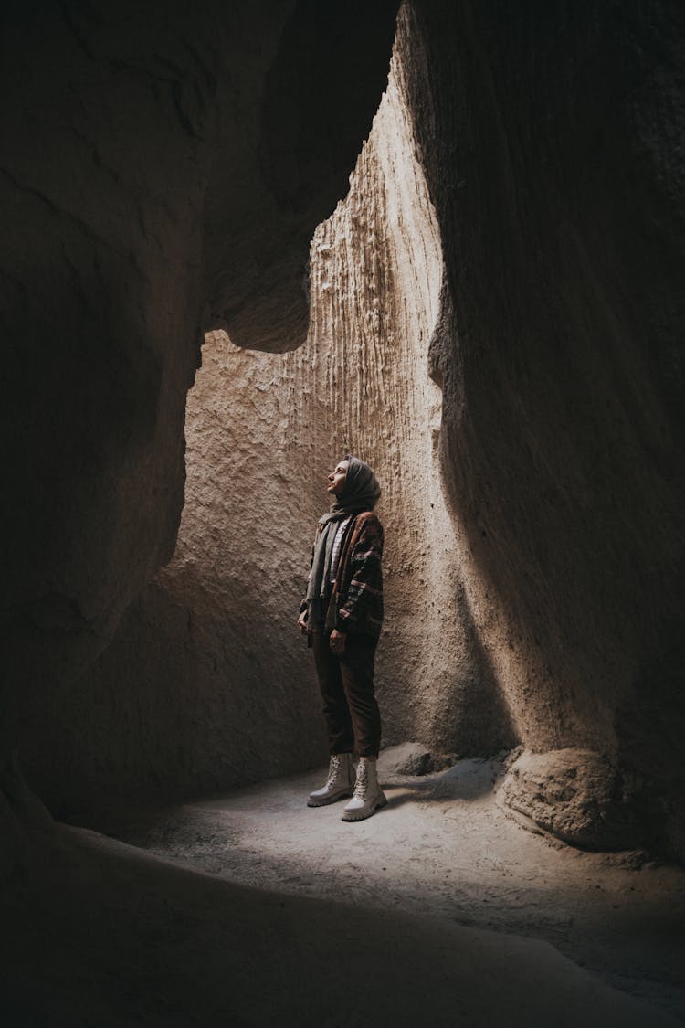 A Person Standing In A Cave