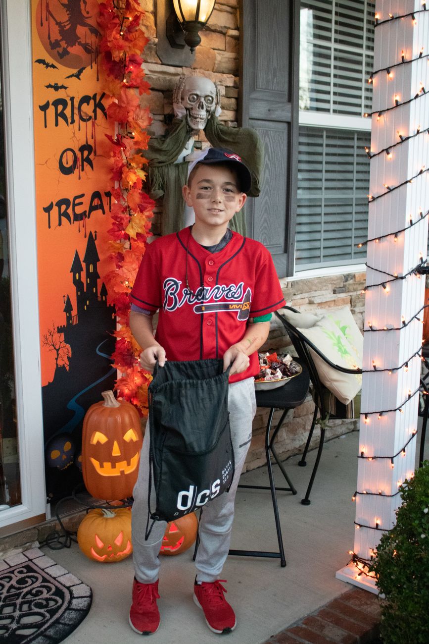 Child dressed as a baseball player trick-or-treating in Fletcher, NC during Halloween.