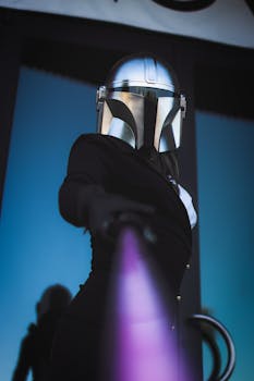 Person in sci-fi costume with helmet and purple lightsaber posing artistically.