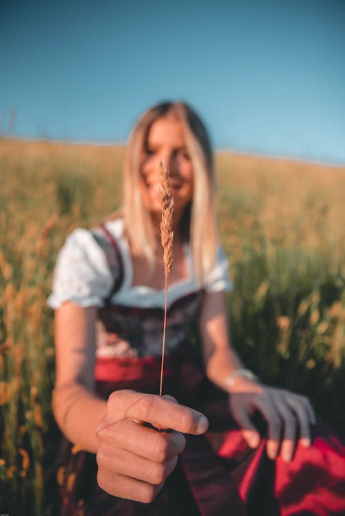 Selective Focus Photography Of Woman Holding Wheat