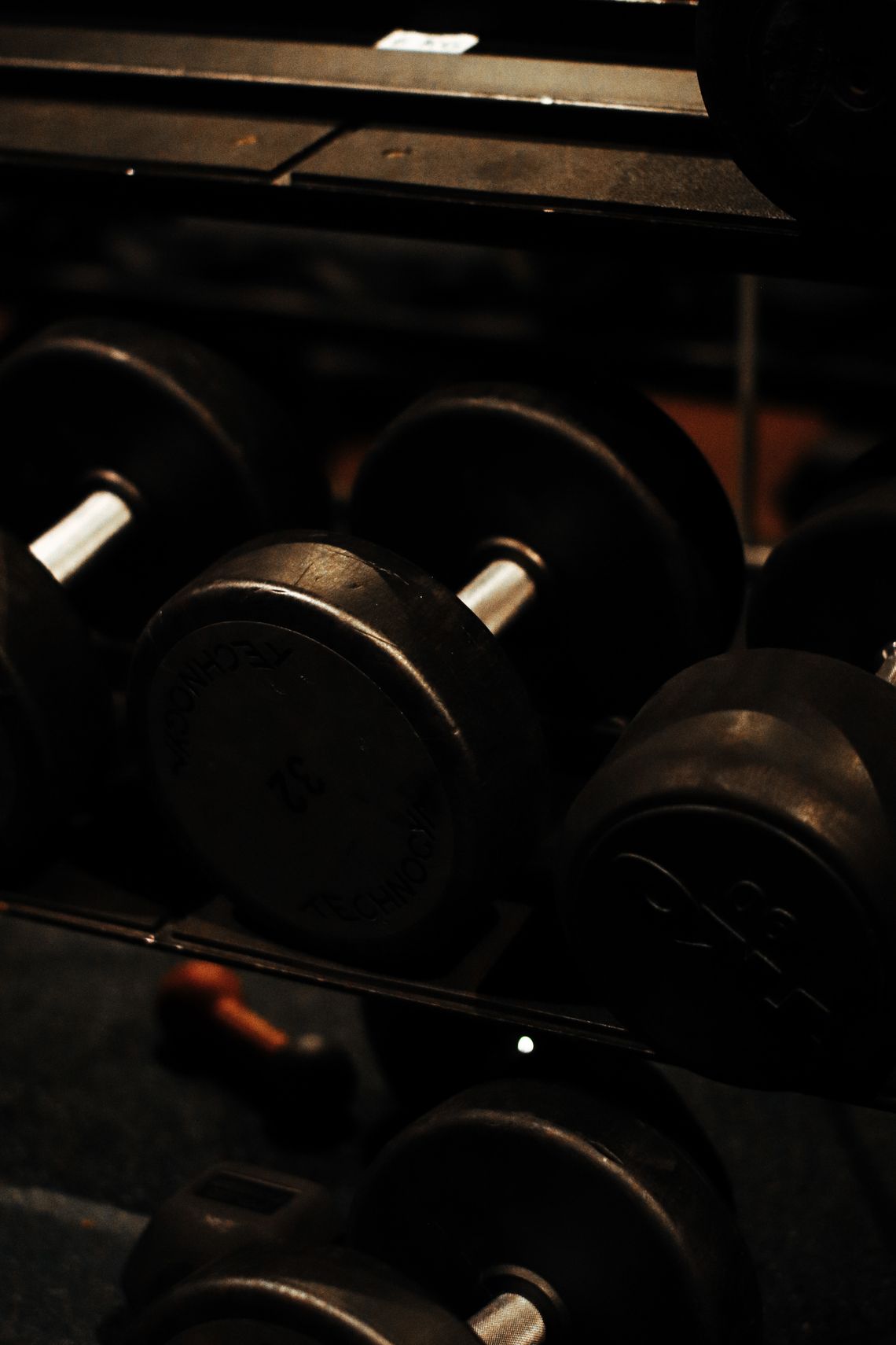 Real heavy dumbbells arranged on a professional strength training rack