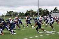 绿茵场上，足球运动员们在多云的天空下进行着一场竞技比赛