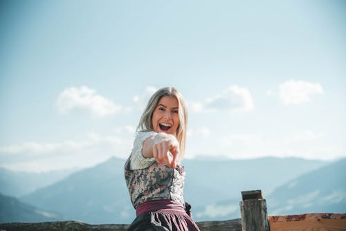 Mulher Sorridente Usando Vestido Floral Apontando Com A Mão Direita