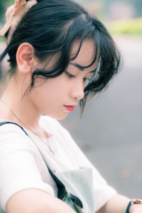 Free A serene and contemplative portrait of a young woman in an outdoor setting, showcasing elegance and tranquility. Stock Photo