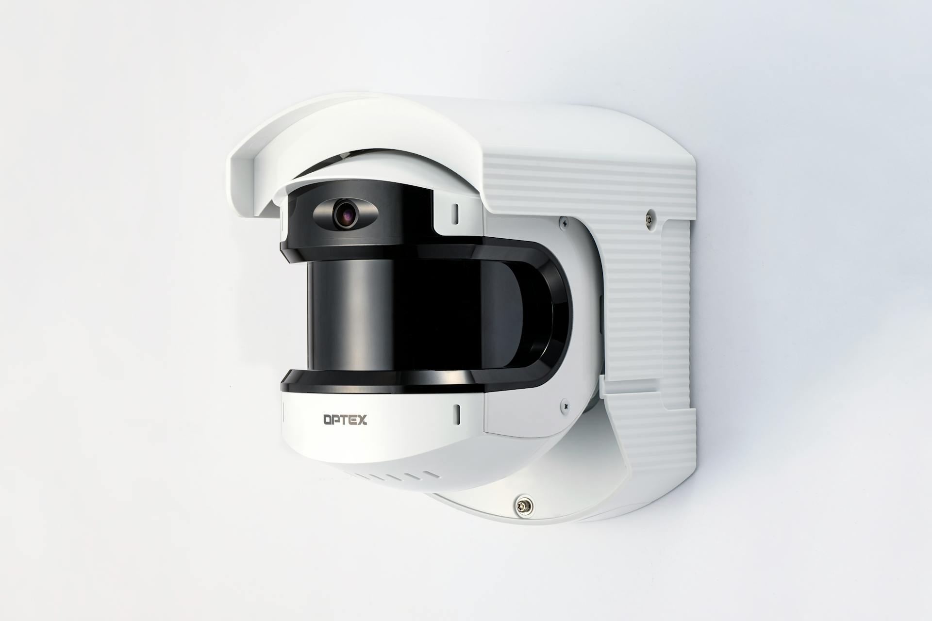 Close-up of a modern white security camera mounted on a wall.