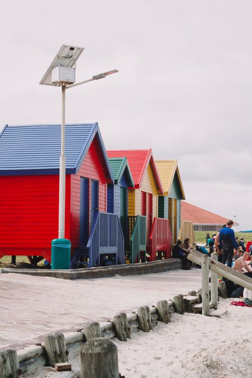 Free Brightly colored beach houses along the shore in Cape Town, perfect for travel and architecture themes. Stock Photo