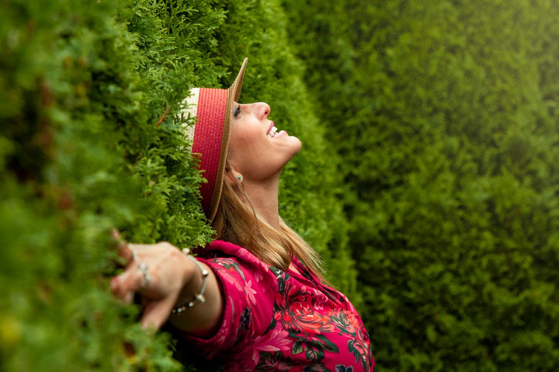 Woman in Red Floral Shirt Lying on Grass Field