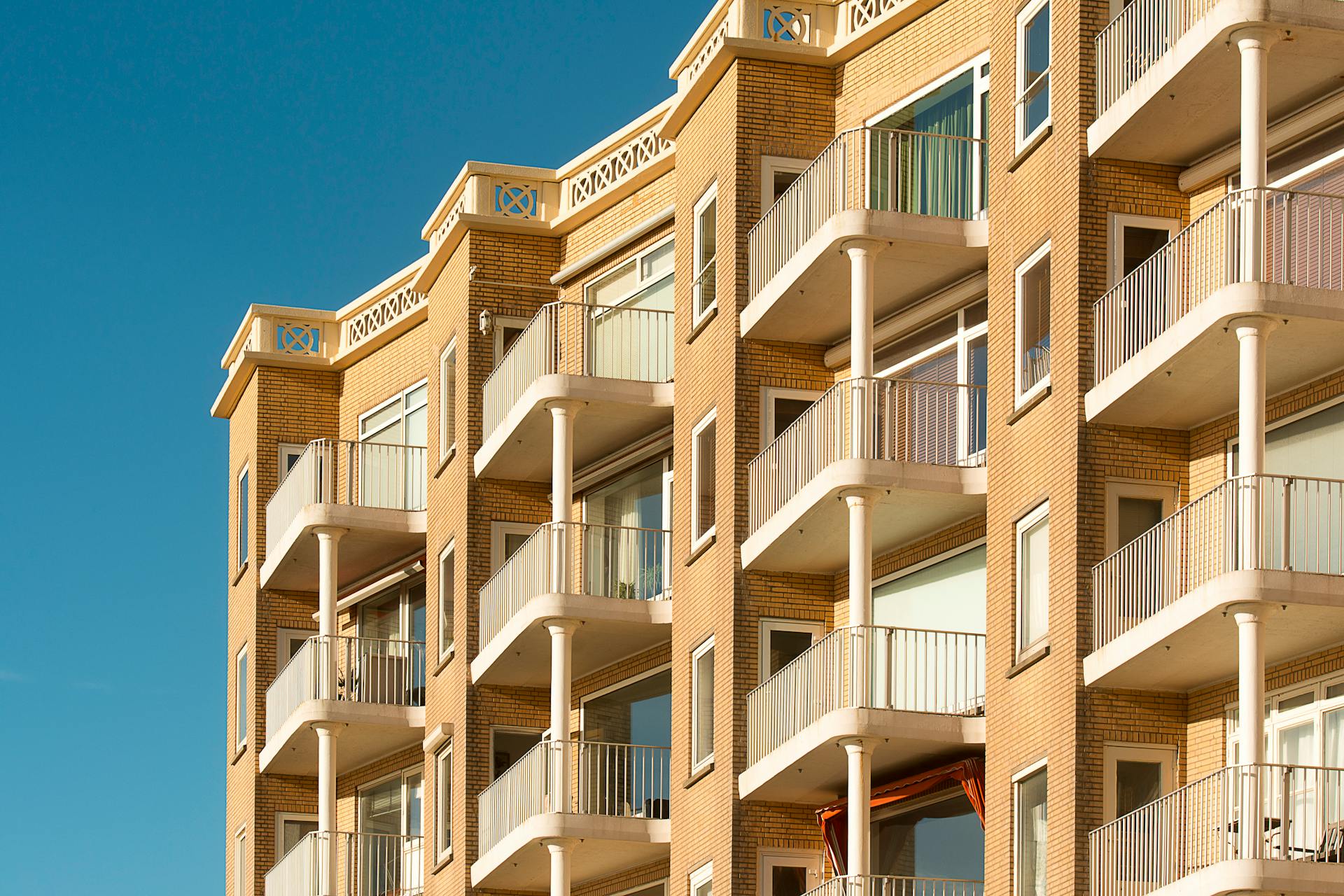 Contemporary apartment building featuring multiple balconies, ideal for urban living environments.