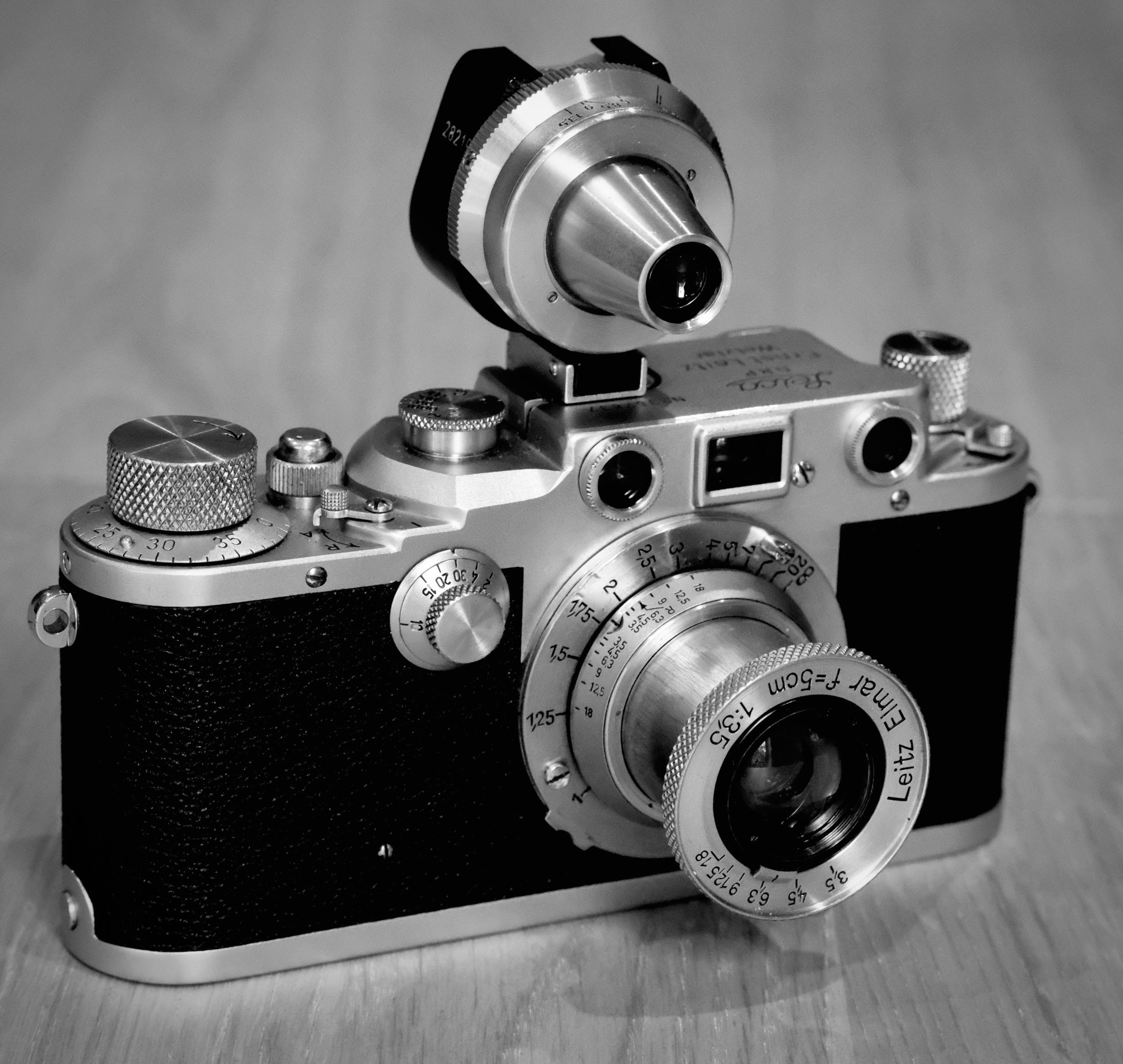 Grayscale Photo of a Camera on Wooden Surface · Free Stock Photo