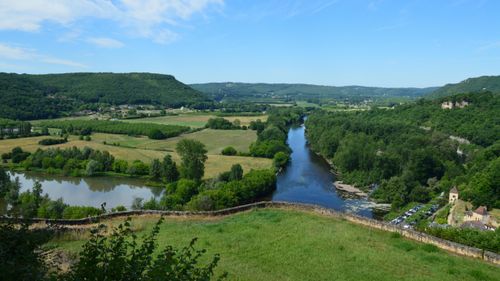 Free A picturesque view of a river winding through lush fields and forests. Stock Photo