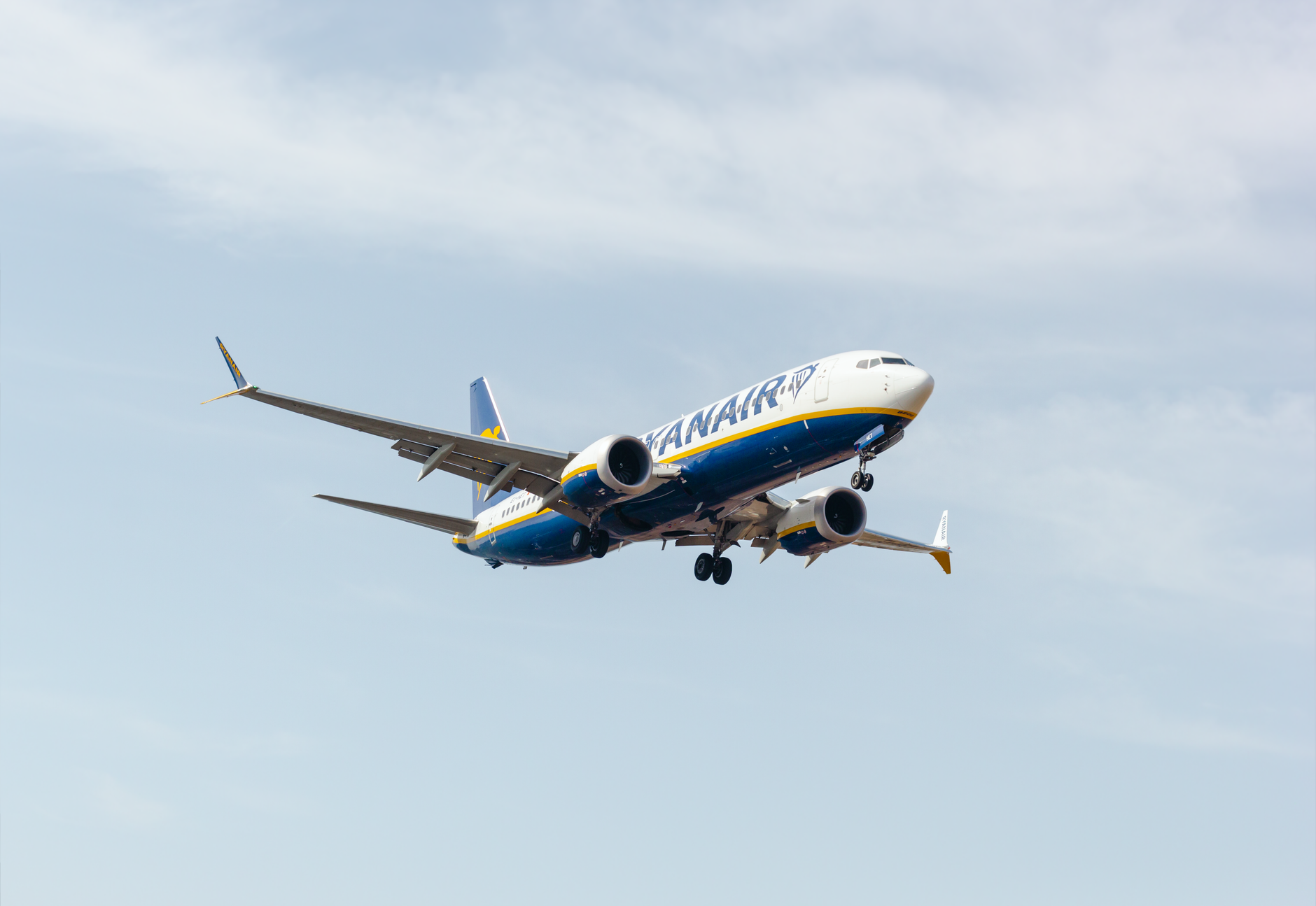 Vertrekhal op een Spaanse luchthaven met reizigers richting gate voor vlucht naar Italië.