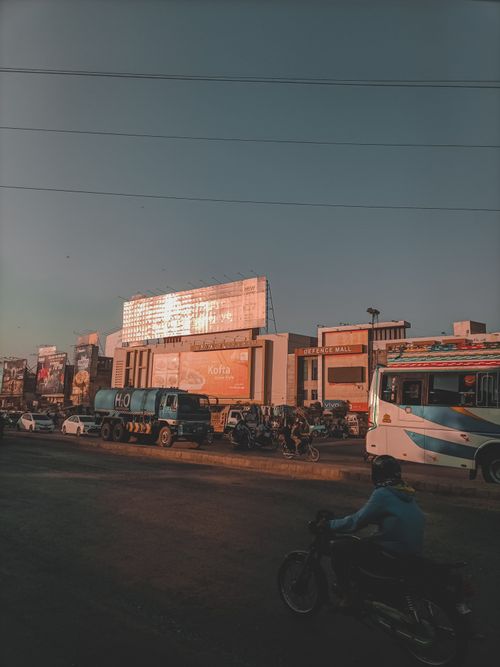 Free Street view of Karachi, showing busy traffic and modern buildings at sunset. Stock Photo