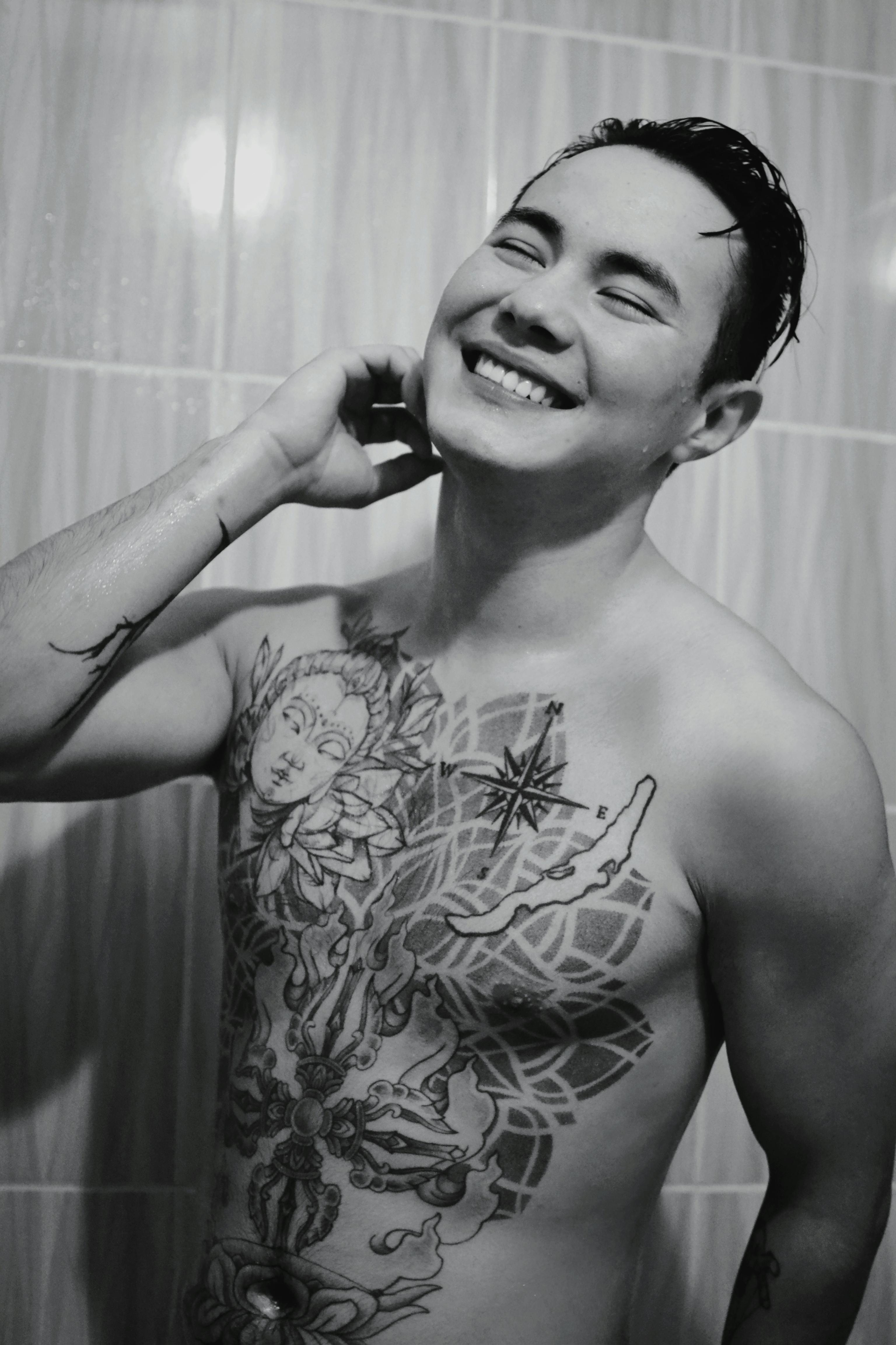 tattooed man in topless smiling
