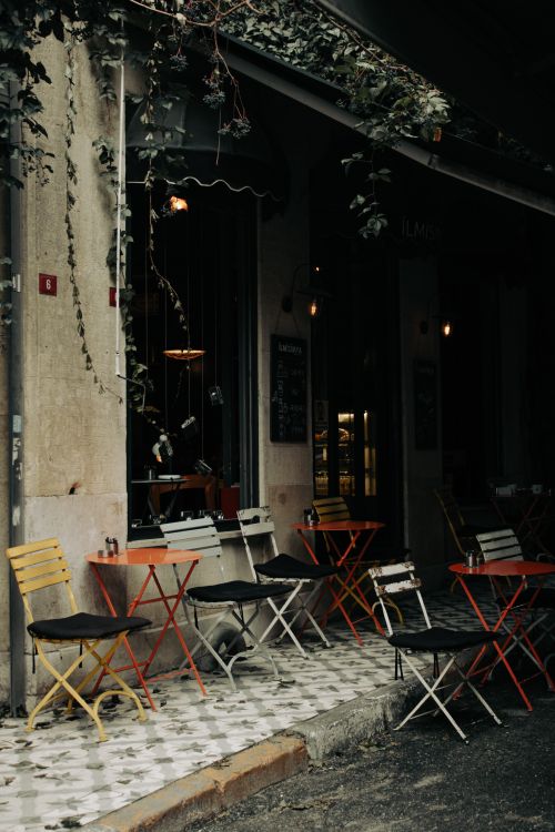 Free Charming outdoor cafe with colorful chairs, perfect for urban exploration and relaxation. Stock Photo