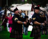 Two Men Playing Wind Instruments on Ground