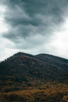 Moody mountain landscape with stormy clouds overhead, capturing nature's dramatic beauty.